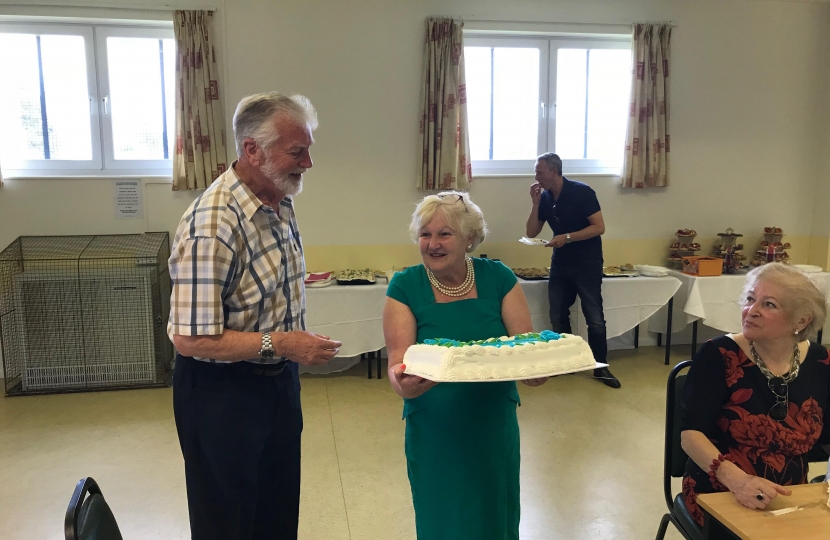 Cllr Helen Manghnani presents Tom Steele with a thank-you Cake