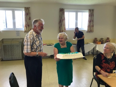 Cllr Helen Manghnani presents Tom Steele with a thank-you Cake